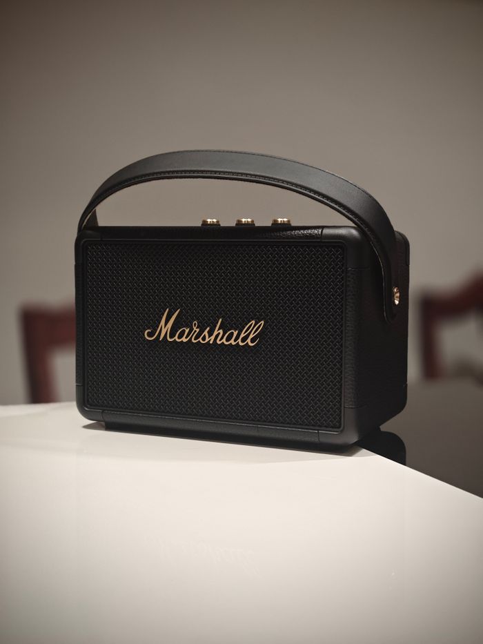 Stylish black portable speaker with handle, ideal for indoor use and music lovers.